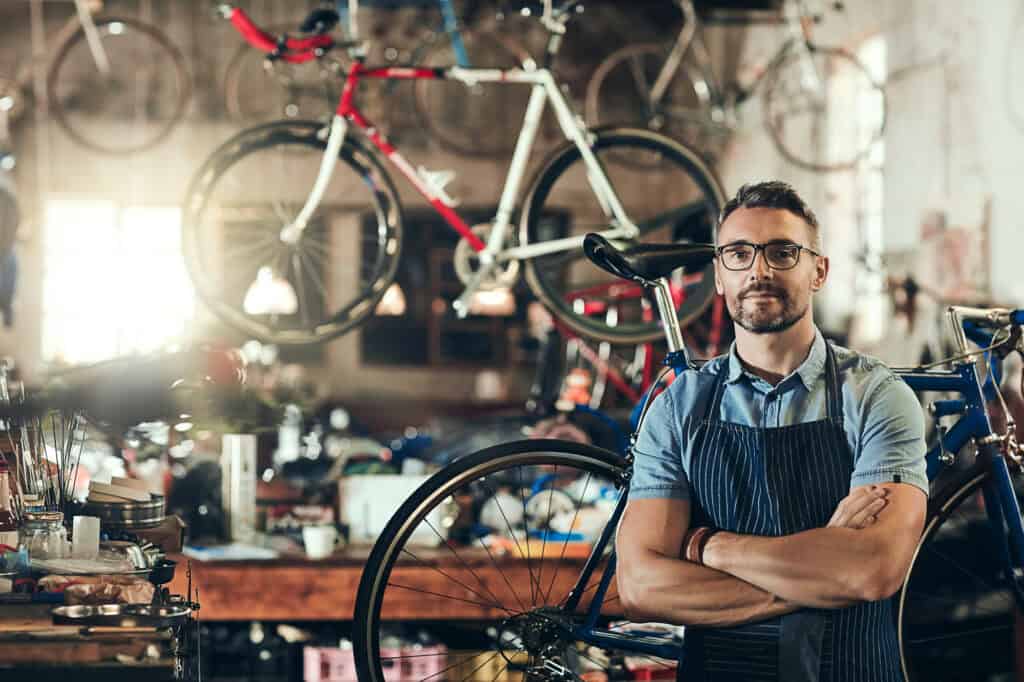 Fahrradmechaniker in Werkstatt mit Fahrrädern